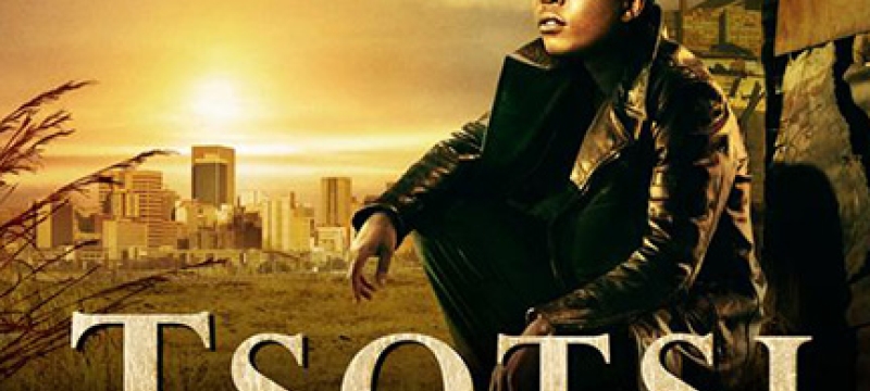 man kneeling with city in background