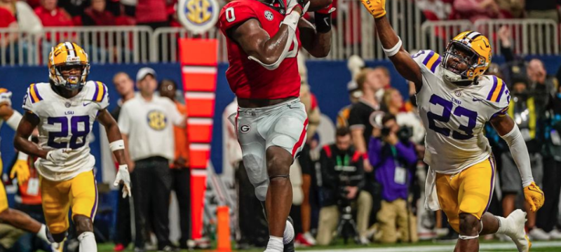 photo of in game football action, three players, fans in background