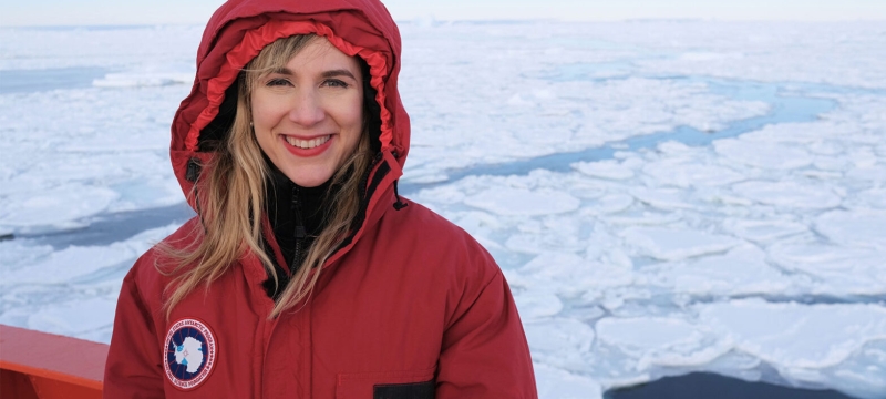 photo of woman in red coat, ice-coverd sea in background