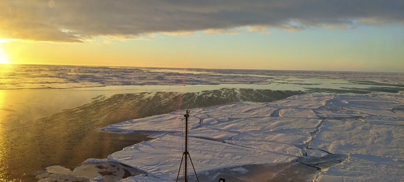 photo of sunrise over frozen sea, with bow of ship