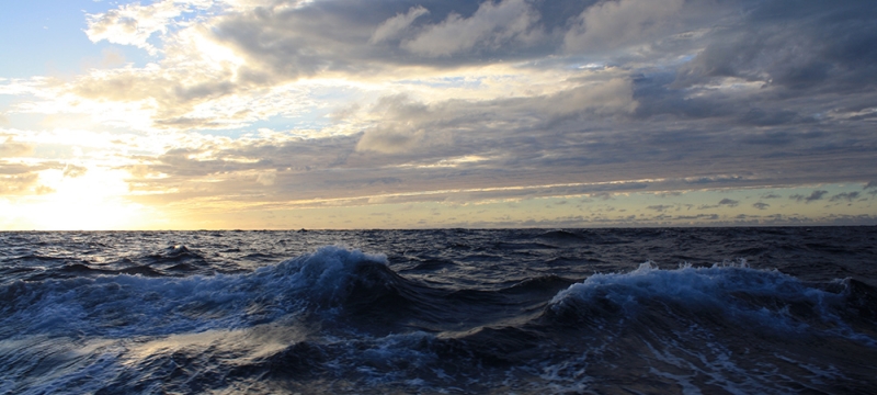 photo of breaking waves in ocean with clouds and sky