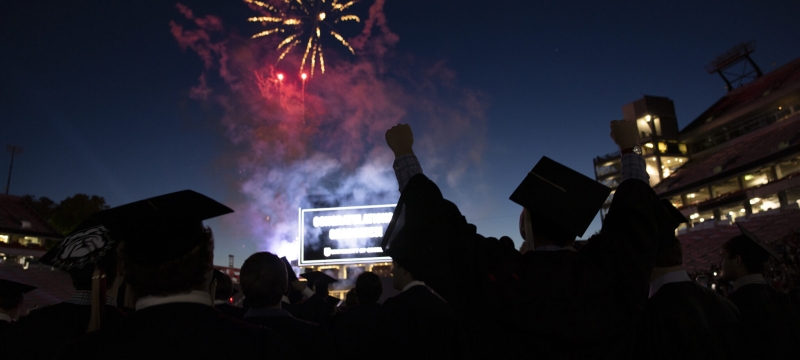photo with fireworks and silhouette of graduate
