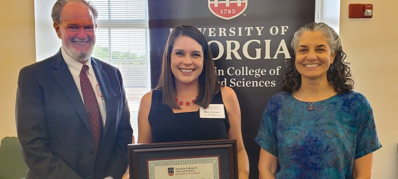 photo of three people, with banner and window