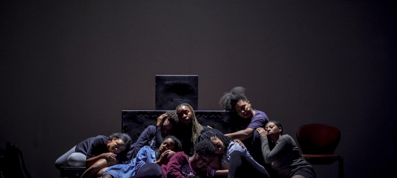 photo of people sitting close together on a darkened stage