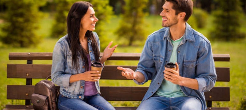 photo of two people sitting on bench, day