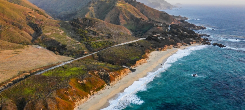 aerial photo of the California coast, with mountains and ocean