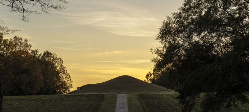 photo of earth mound, covered with grass, twilight