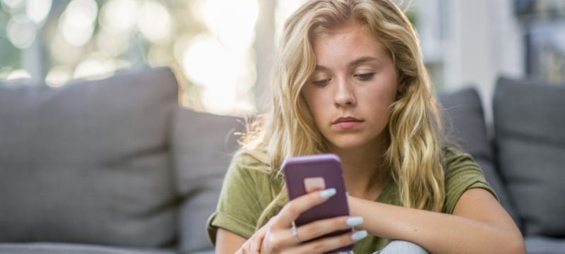 Photo of woman seated looking into cell phone