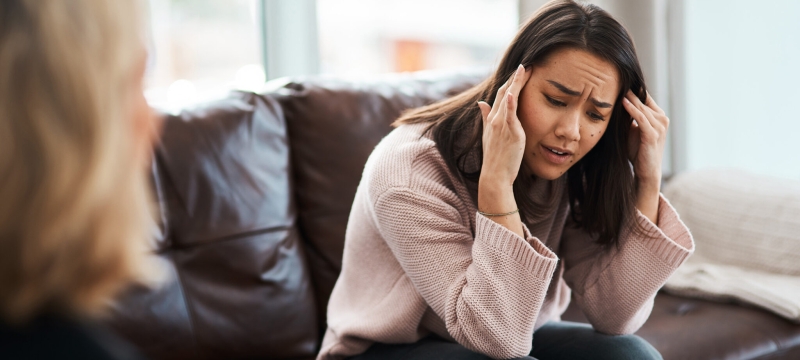 photo of woman, with hands at temples