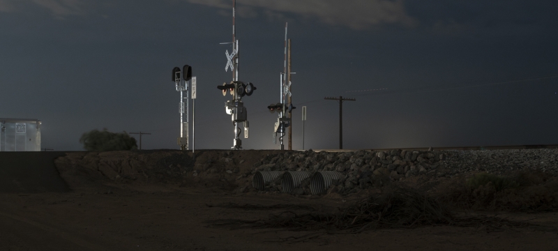 photo of a railroad crossing at night