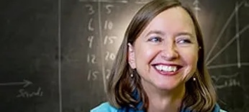 photo of woman, with blackboard in background