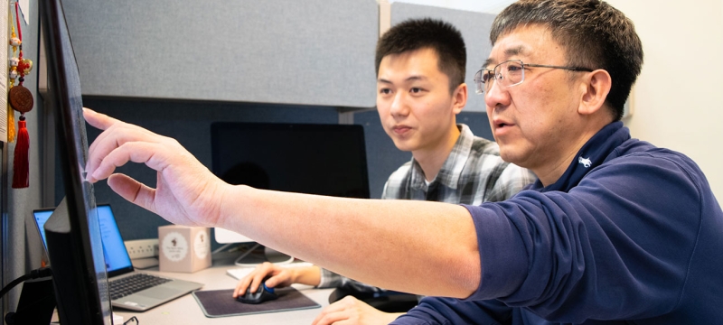 photo of two men at a computer screen