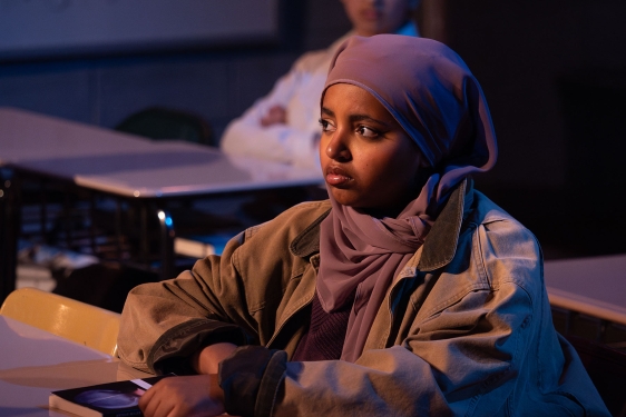 photo of woman, sitting at desk with book