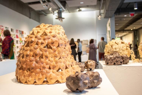 photo of sculpture and people at an art exhibition