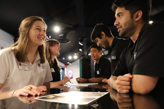 photo of people talking cross desk