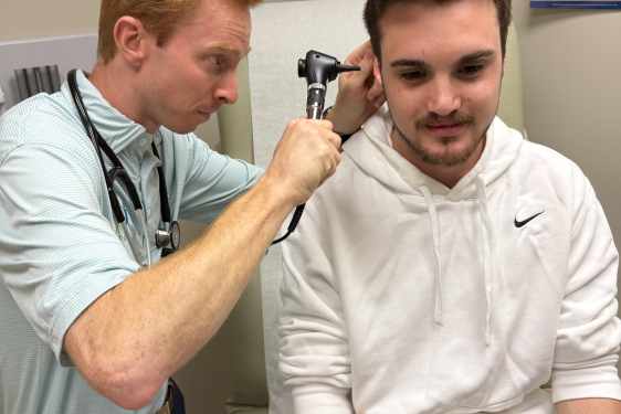 Cole Phillips checking patient's ear