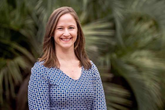 photo of woman with palm fronds in background 