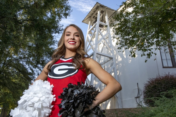 photo of cheerleader in front of the chapel bell