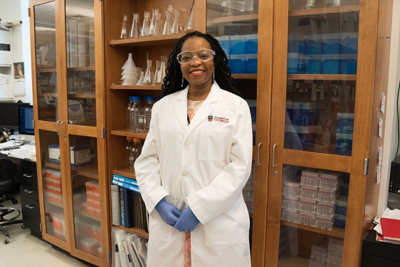photo of woman in laboratory, in what lab coat with shelves and bottles