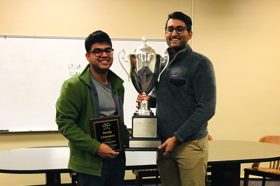 photo of two men with trophy and plaque