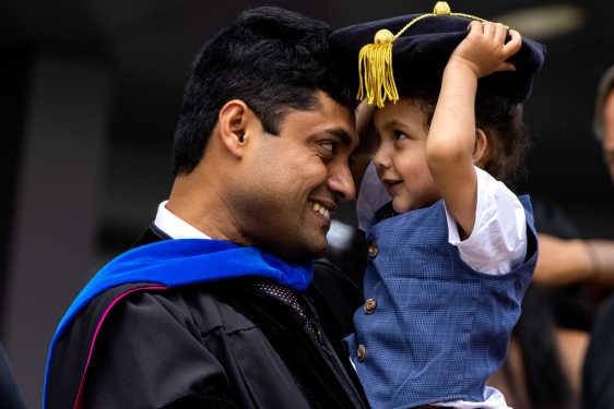 photo of man and child with cap and gown