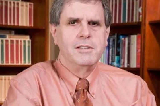 photo of man with books in background