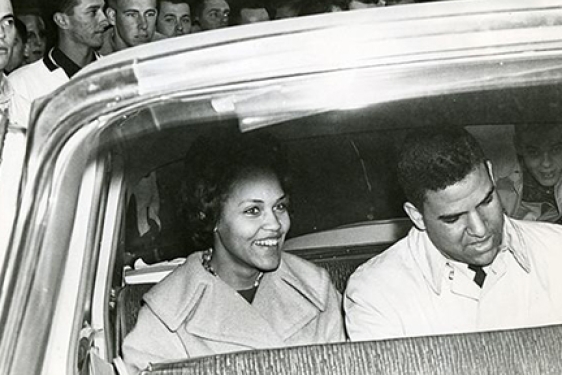 b/w photo of two people in a car, from outside
