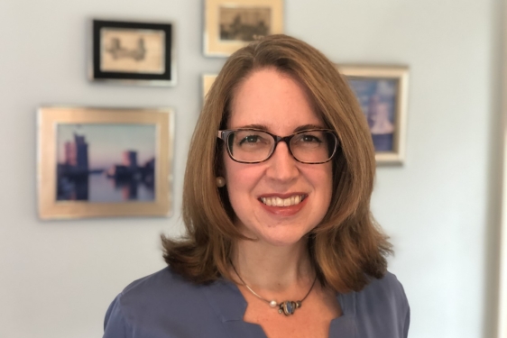 photo of woman, with framed images in background
