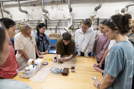 photo of nine people around a table, with small tools