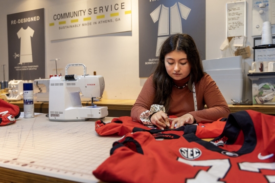 photo of woman sewing a red jersey