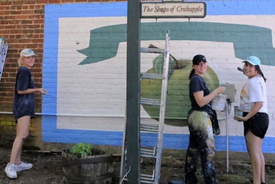 photo of three women painting a mural