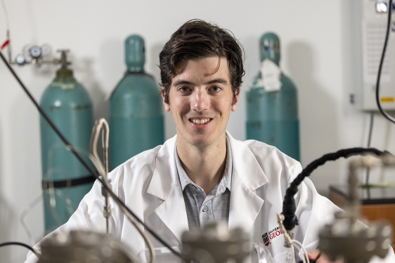photo of man in lab coat, with lab equipment