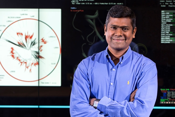 photo of man in front of computer screen projection