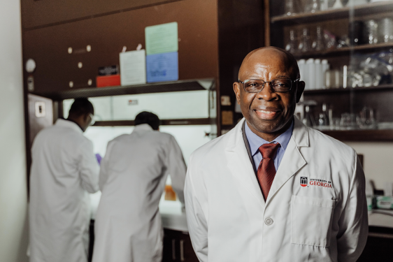 photo of man in lab, with two people in background
