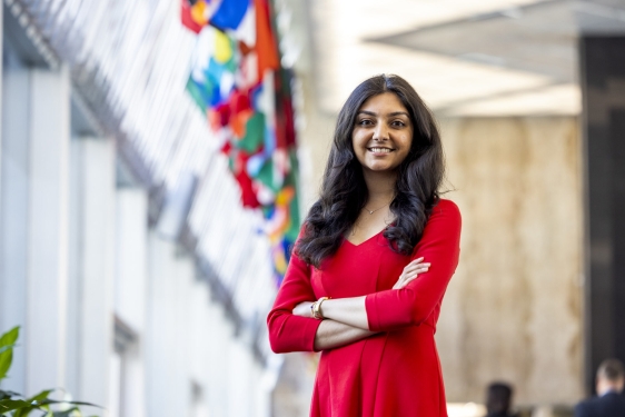 photo of woman, with row of flags in background 