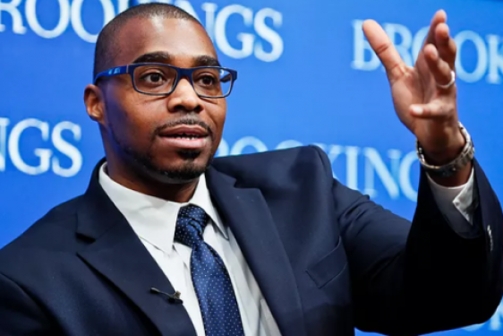 photo of man gesturing, blue background