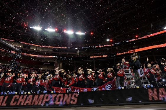 photo of marching band members in seats at stadium