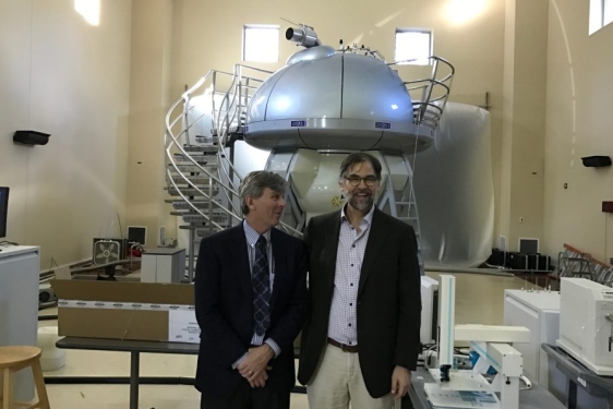 photo of men with NMR machine in background 