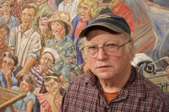 photo of man in front of mural