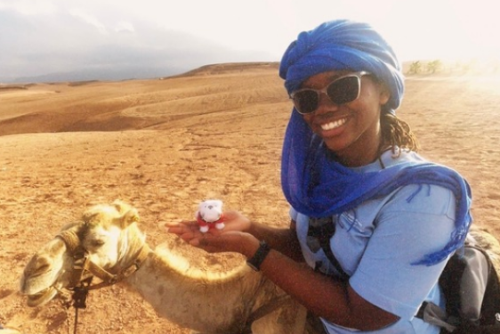 photo of woman with camel, desert in background