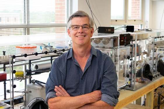photo of man in research lab, arms folded