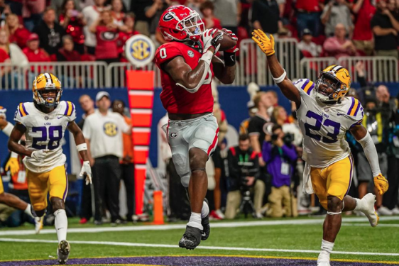 photo of in game football action, three players, fans in background