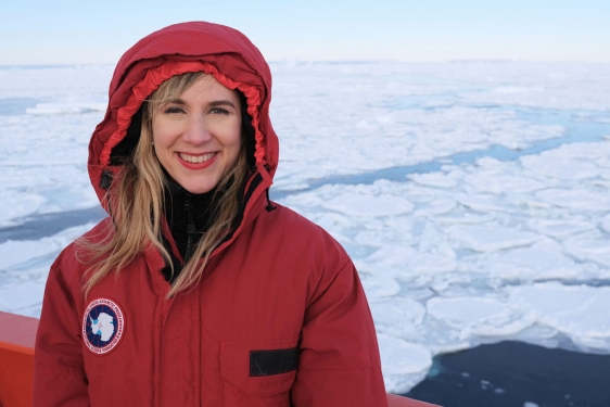 photo of woman in red coat, ice-coverd sea in background