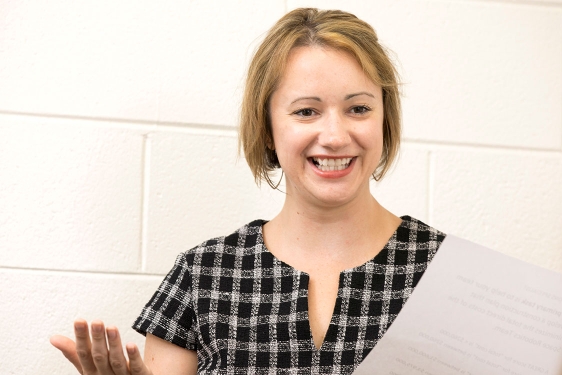 photo of woman holding paper, indoors