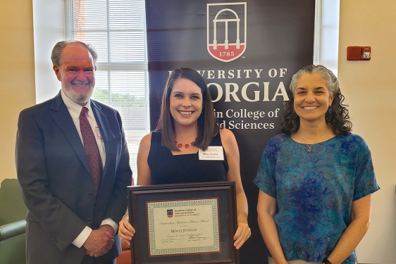 photo of three people, with banner and window
