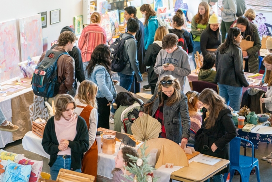 photo of people, tables and objects at an artist's market