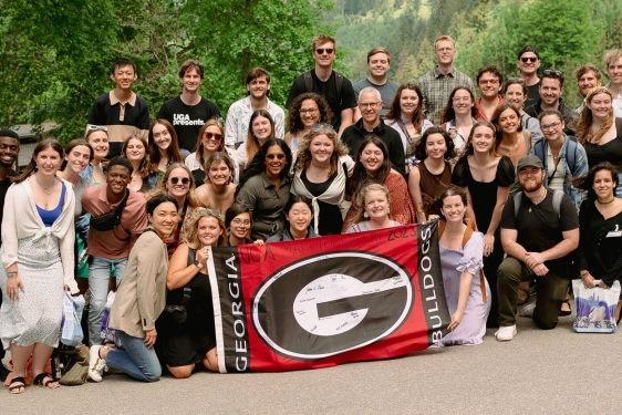 group photo of people, with super 'G' flag at center