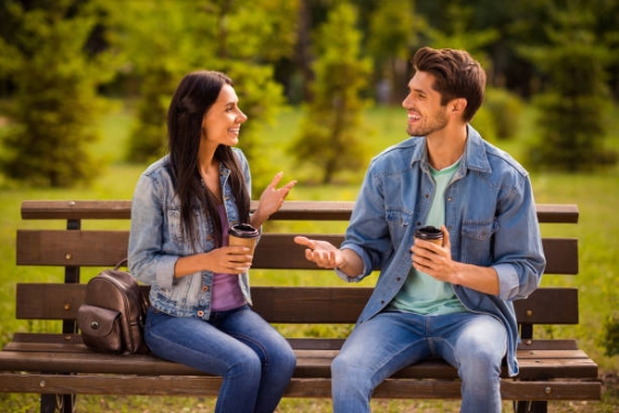 photo of two people sitting on bench, day