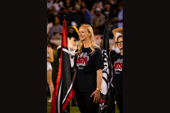 photo of woman on field, with flag