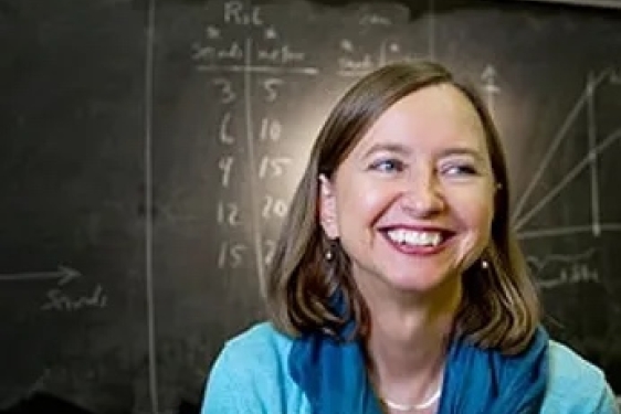 photo of woman, with blackboard in background